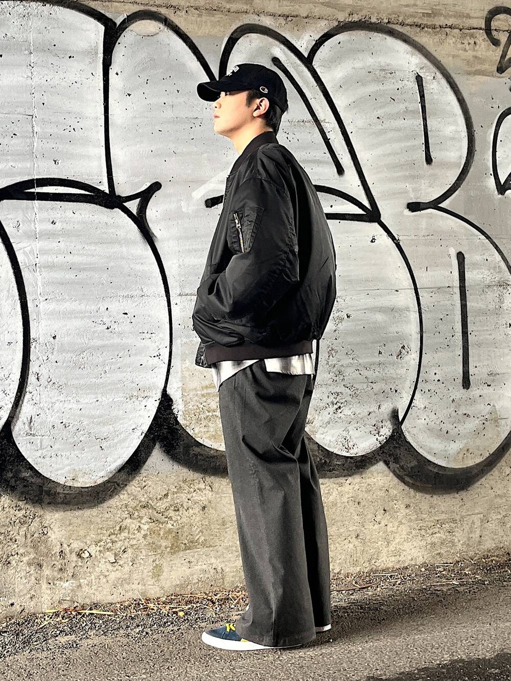 グレー系のスラックス、ブラック系のMA-1、ブラック系のシャツ/ブラウスを着用したメンズの冬コーディネートの2枚目の写真