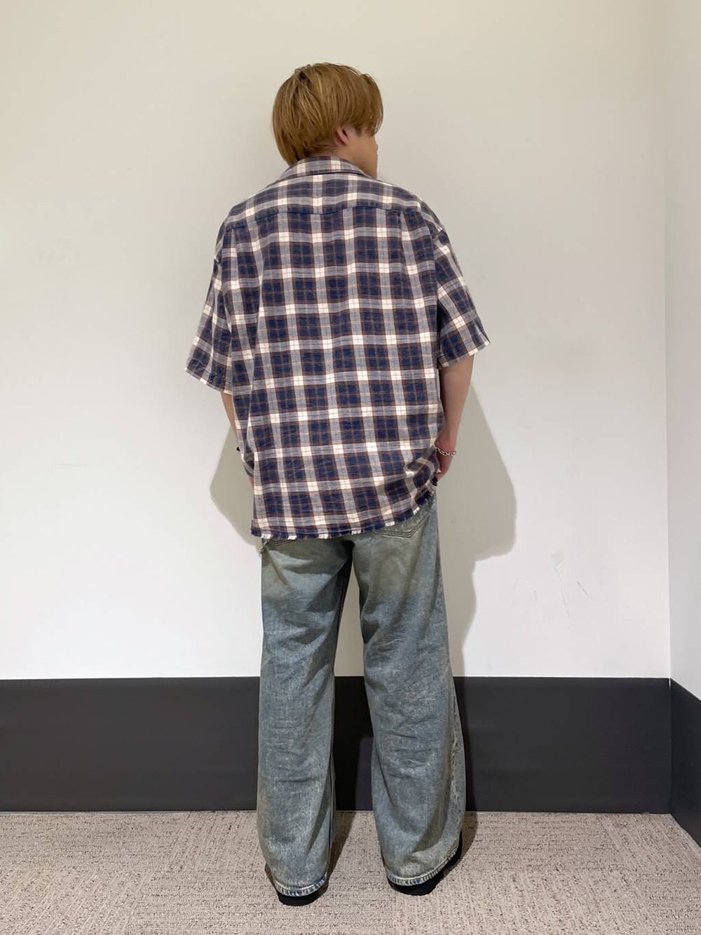 ブラック系のドレスシューズ、ブラック系のタンクトップ、ブルー系のデニムパンツを着用したメンズの夏コーディネートの3枚目の写真