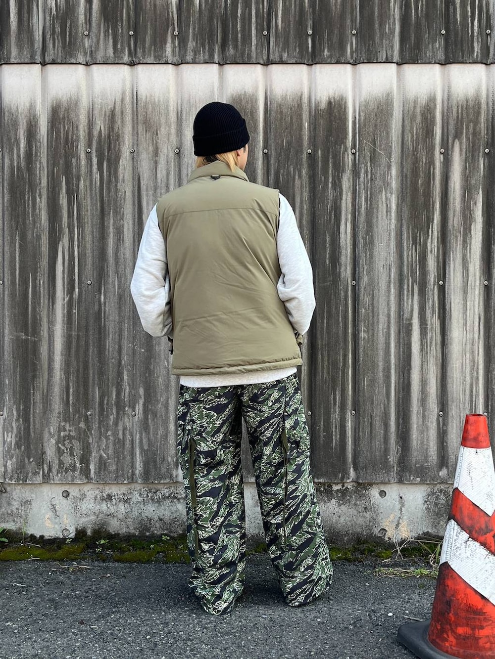 ブラウン系のダウンベスト、グリーン系のカーゴパンツ、ホワイト系のスウェットを着用したメンズの秋コーディネートの3枚目の写真