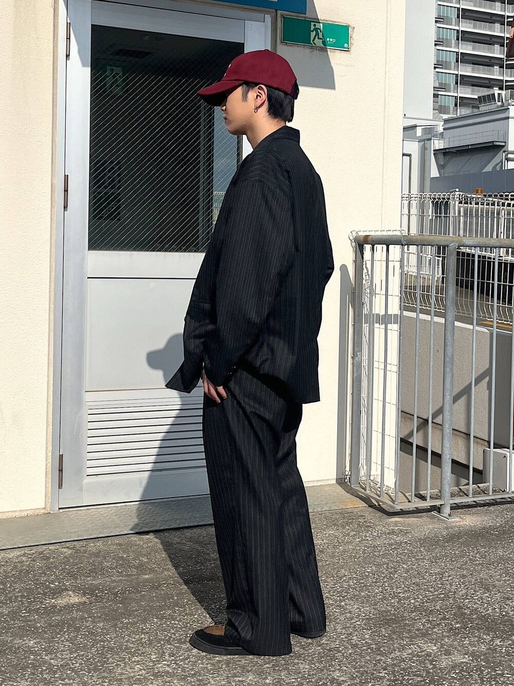 ブラック系のテーラードジャケット、ブラック系のスラックス、ブラック系のスウェットを着用したメンズの冬コーディネートの2枚目の写真