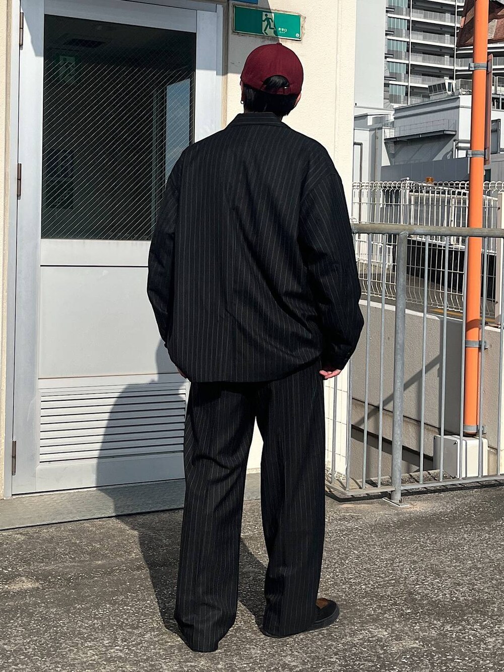 ブラック系のテーラードジャケット、ブラック系のスラックス、ブラック系のスウェットを着用したメンズの冬コーディネートの3枚目の写真