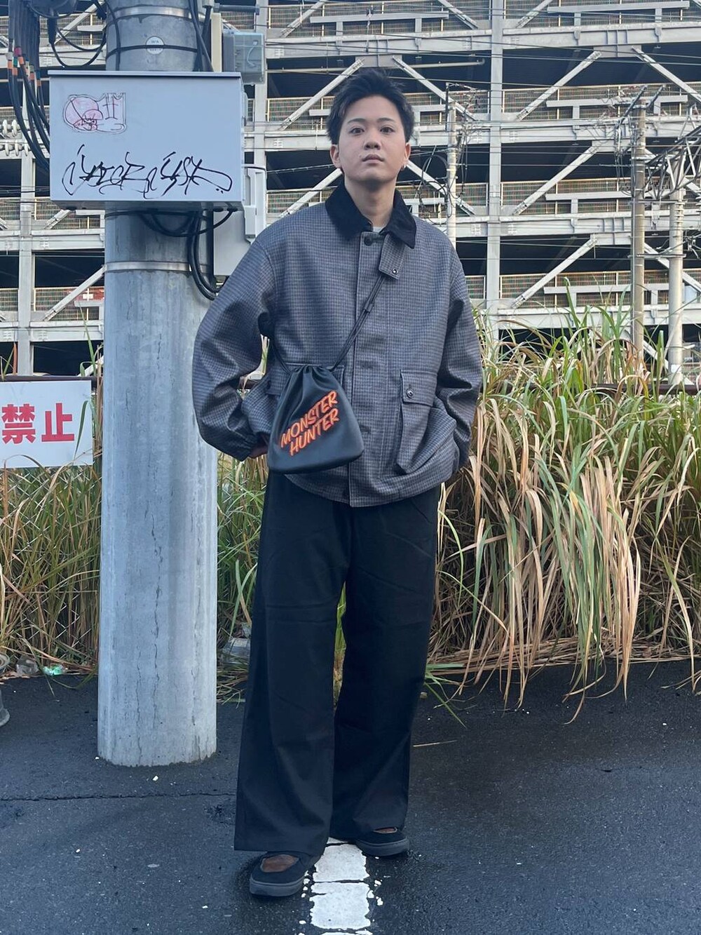 グレー系のブルゾン、ブラック系のスラックス、グレー系のスウェットを着用したメンズの秋コーディネートの4枚目の写真