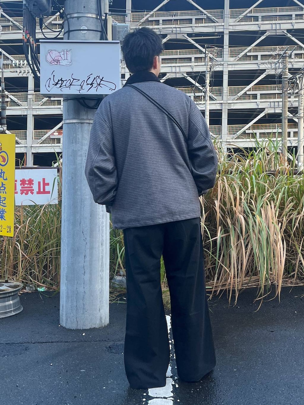 グレー系のブルゾン、ブラック系のスラックス、グレー系のスウェットを着用したメンズの秋コーディネートの3枚目の写真