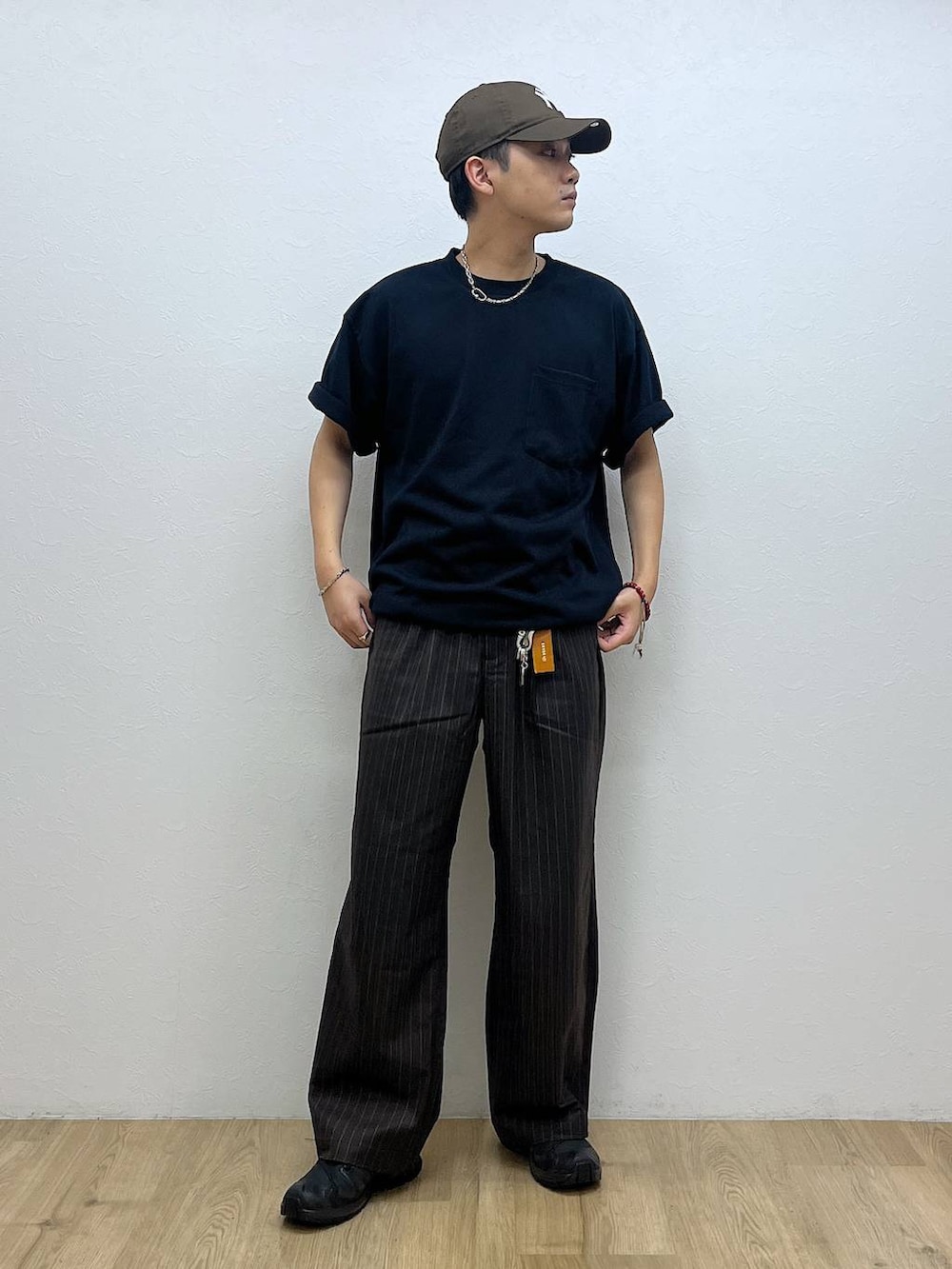 ブラック系のスニーカー、ブラウン系のスラックス、ブルー系のTシャツ/カットソーを着用したメンズの夏コーディネートの4枚目の写真