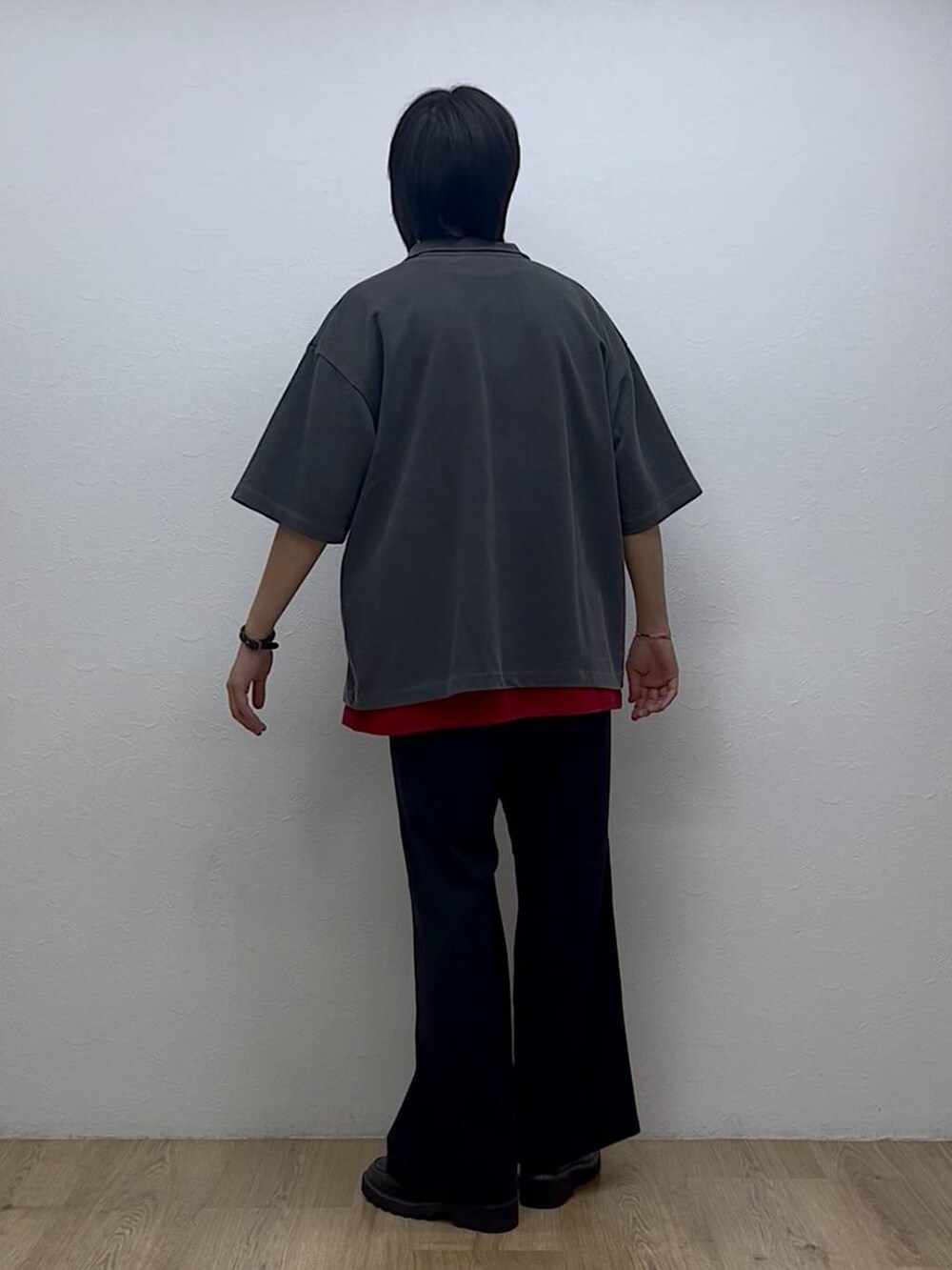 ブラック系のスラックス、ブラック系のドレスシューズ、レッド系のTシャツ/カットソーを着用したメンズの夏コーディネートの3枚目の写真