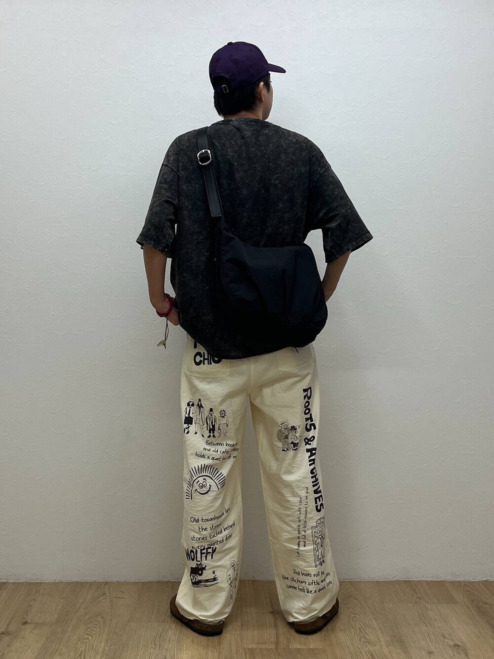 グレー系のTシャツ/カットソー、ブラック系のショルダーバッグ、ホワイト系のチノパンツを着用したメンズの夏コーディネートの3枚目の写真