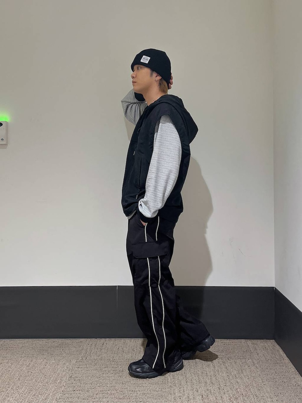 ブラック系のスニーカー、ブラック系のカーゴパンツ、ホワイト系のTシャツ/カットソーを着用したメンズの秋コーディネートの3枚目の写真