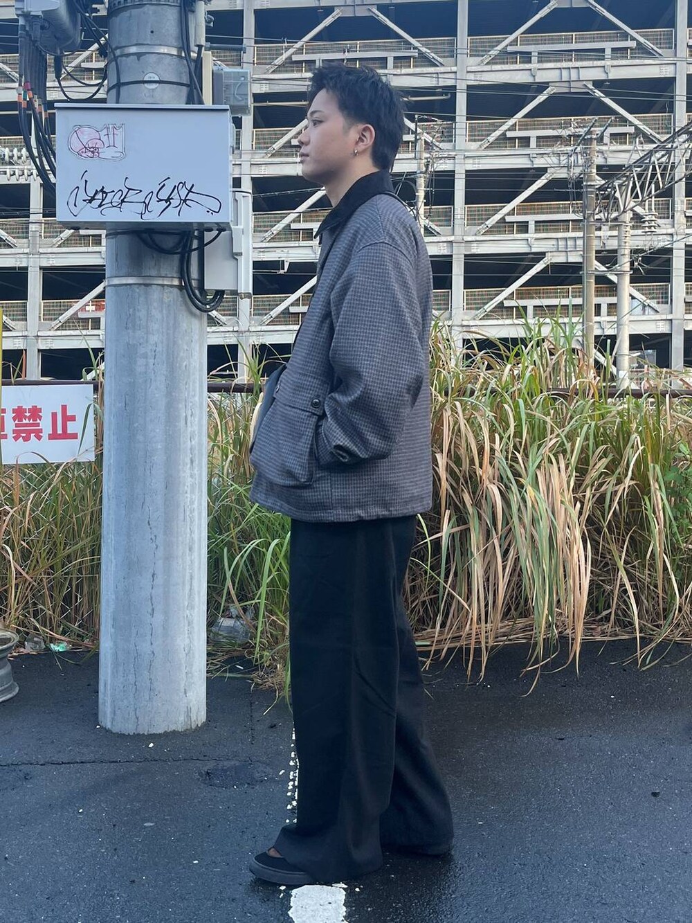 グレー系のブルゾン、ブラック系のスラックス、グレー系のスウェットを着用したメンズの秋コーディネートの2枚目の写真