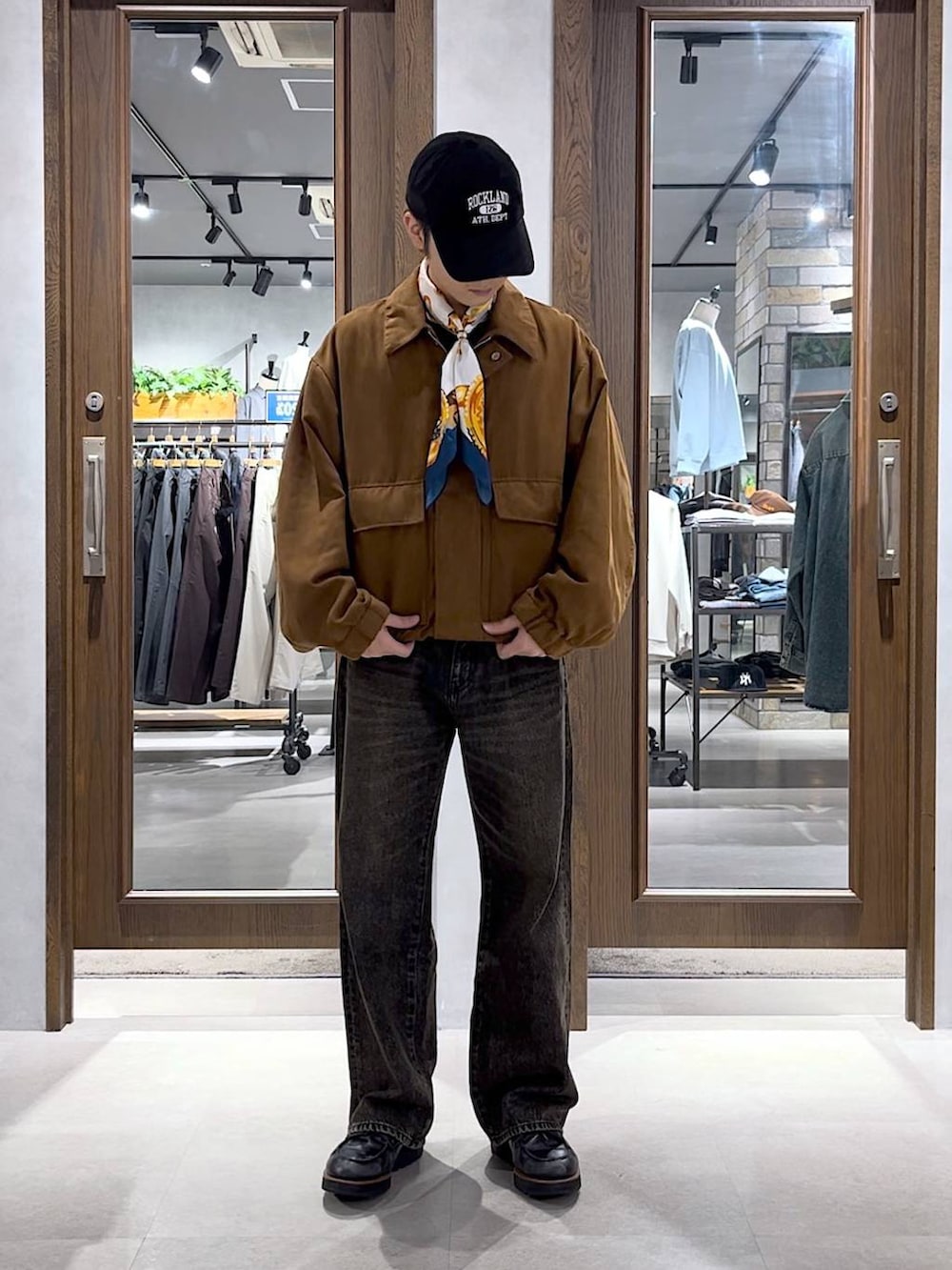 グレー系のデニムパンツ、イエロー系のブルゾン、ブラック系のキャップを着用したメンズの秋コーディネートの4枚目の写真