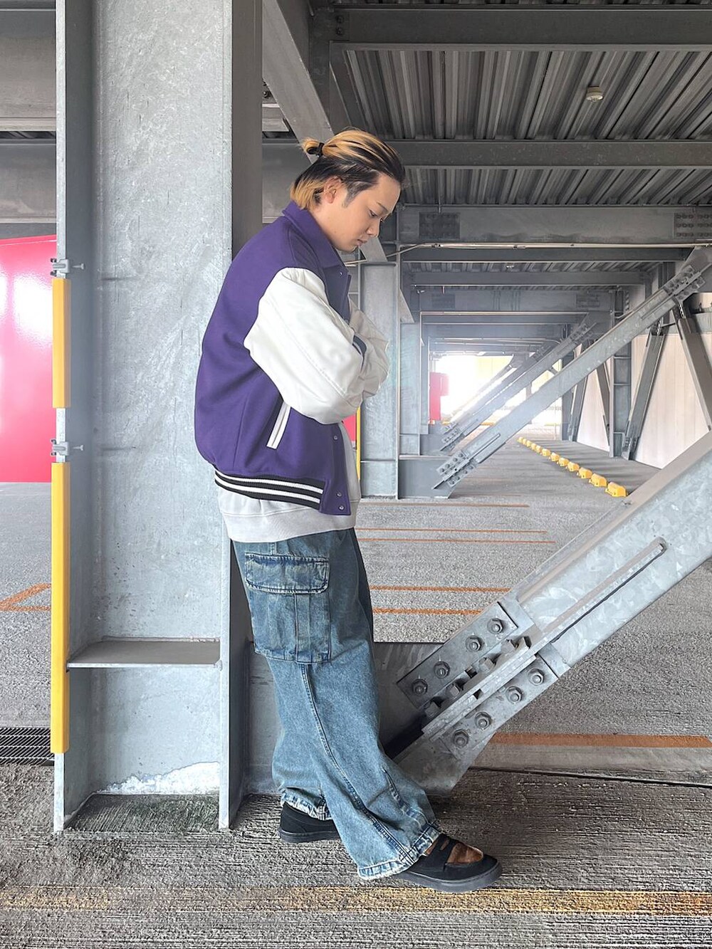 パープル系のスタジャン、ブルー系のデニムパンツ、グレー系のスウェットを着用したメンズの秋コーディネートの2枚目の写真