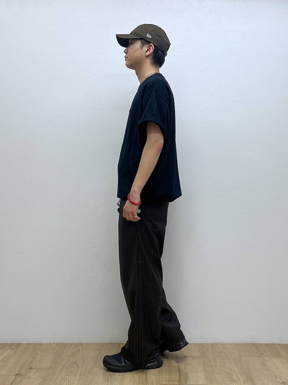 ブラック系のスニーカー、ブラウン系のスラックス、ブルー系のTシャツ/カットソーを着用したメンズの夏コーディネートの2枚目の写真
