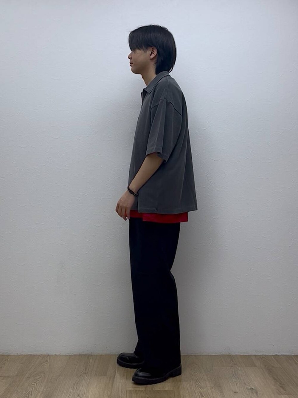 ブラック系のスラックス、ブラック系のドレスシューズ、レッド系のTシャツ/カットソーを着用したメンズの夏コーディネートの2枚目の写真