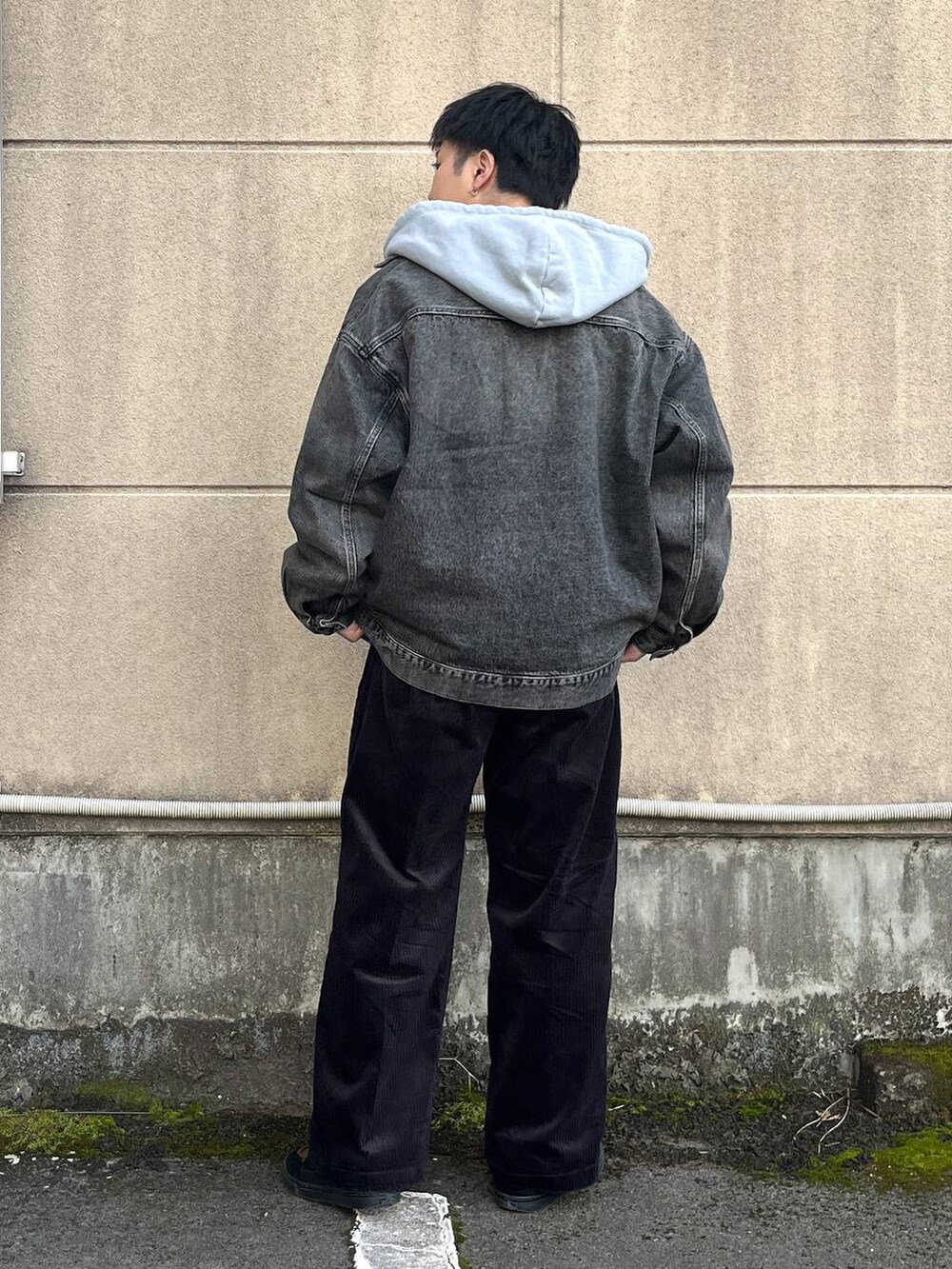 ブラック系のスラックス、グレー系のデニムジャケット、グレー系のパーカーを着用したメンズの冬コーディネートの3枚目の写真