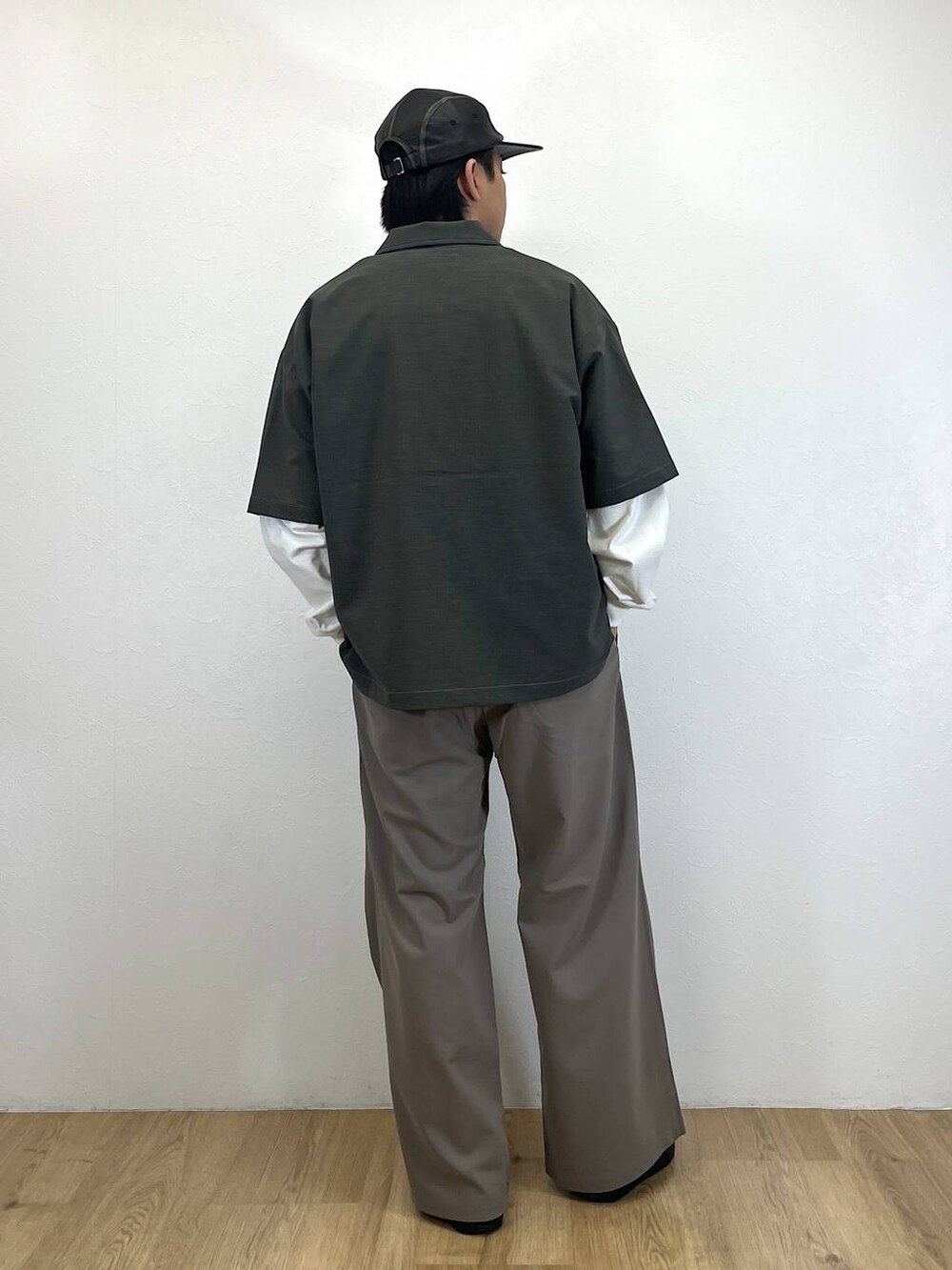 グレー系のシャツ/ブラウス、ホワイト系のTシャツ/カットソー、ベージュ系のスラックスを着用したメンズの春コーディネートの3枚目の写真