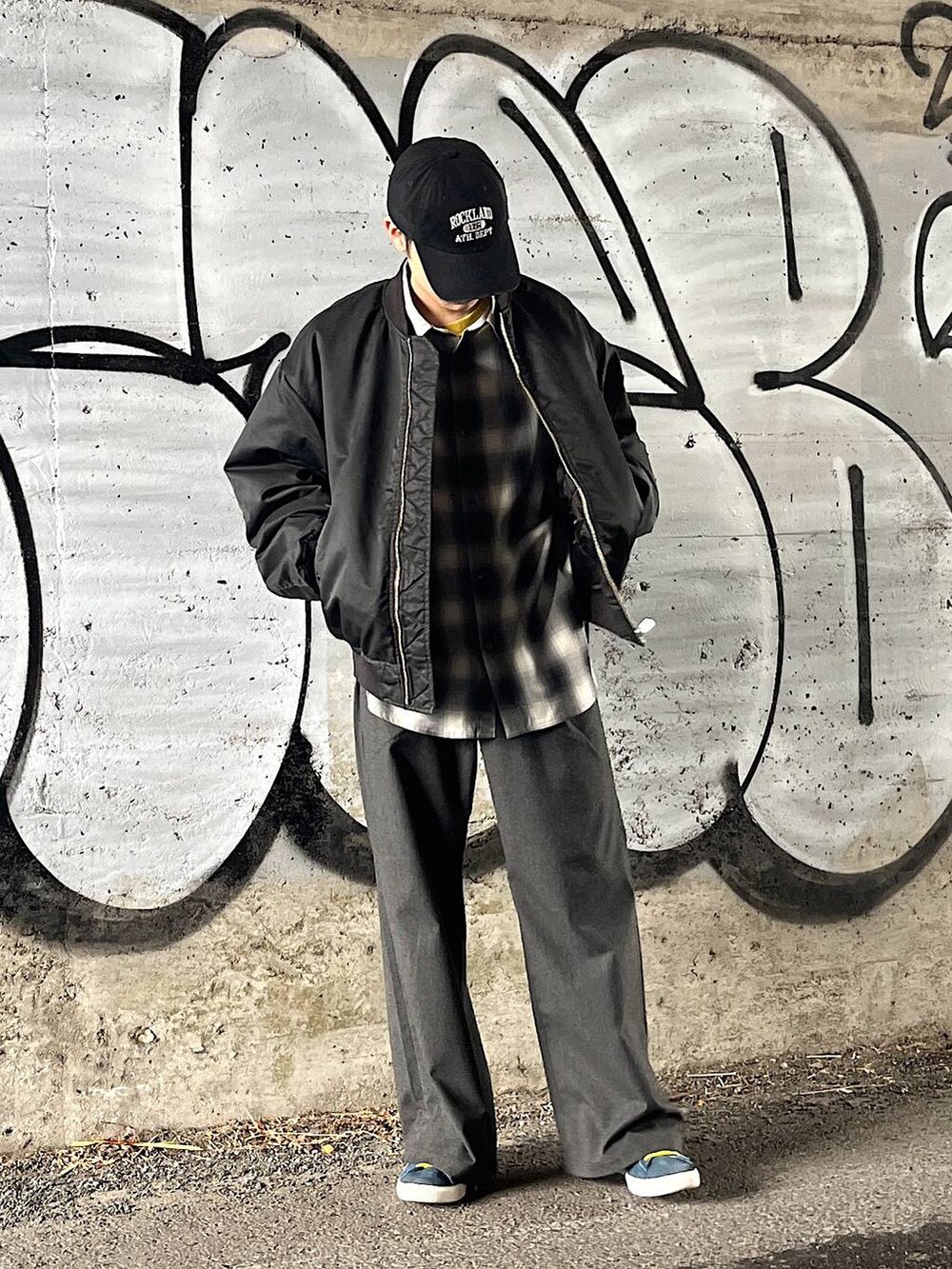 グレー系のスラックス、ブラック系のMA-1、ブラック系のシャツ/ブラウスを着用したメンズの冬コーディネートの4枚目の写真