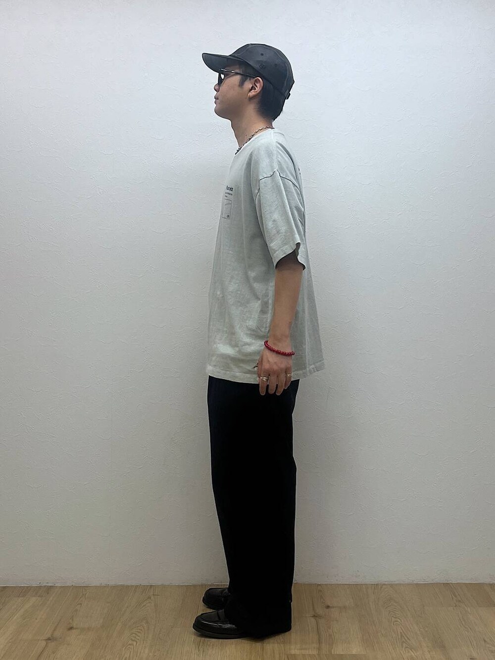 ブラック系のチノパンツ、グレー系のTシャツ/カットソー、ホワイト系のサングラスを着用したメンズの夏コーディネートの2枚目の写真