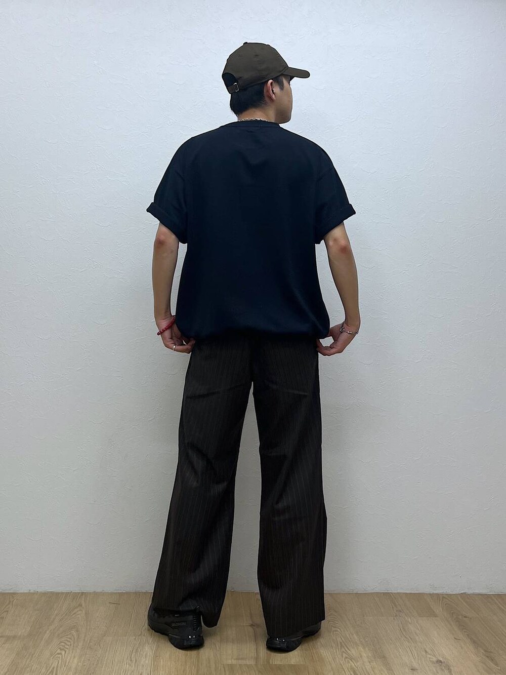 ブラック系のスニーカー、ブラウン系のスラックス、ブルー系のTシャツ/カットソーを着用したメンズの夏コーディネートの3枚目の写真
