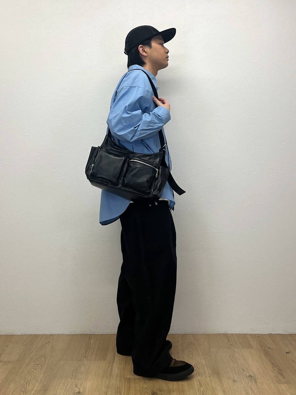 ブラック系のカーゴパンツ、その他のショルダーバッグ、ブルー系のシャツ/ブラウスを着用したメンズの春コーディネートの2枚目の写真