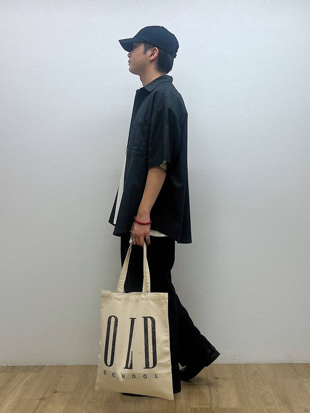 ホワイト系のトートバッグ、ホワイト系のTシャツ/カットソー、ブラック系のシャツ/ブラウスを着用したメンズの夏コーディネートの2枚目の写真