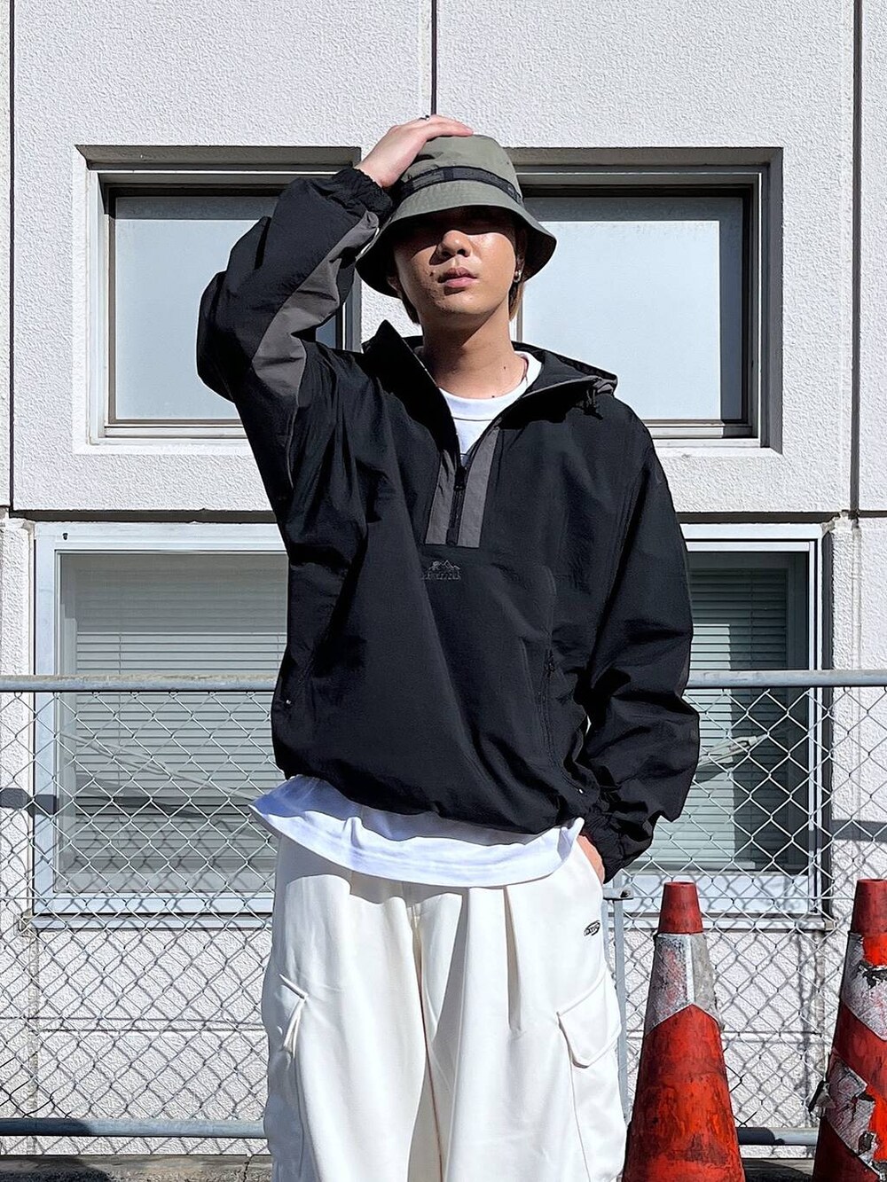 ホワイト系のカーゴパンツ、ブラック系のブルゾン、グリーン系のハットを着用したメンズの秋コーディネートの3枚目の写真