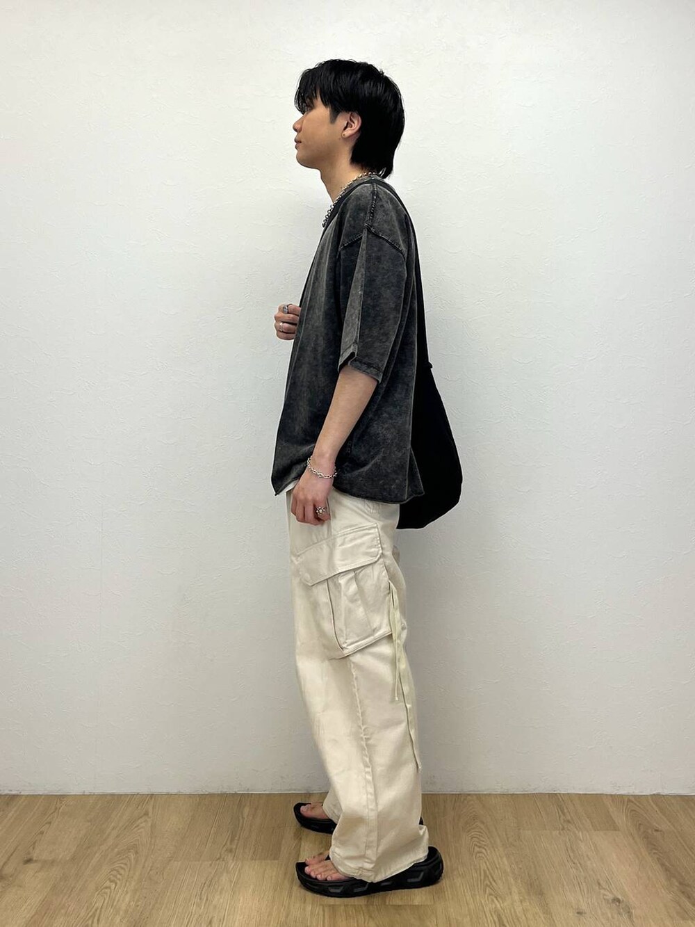 ブラック系のショルダーバッグ、ホワイト系のカーゴパンツ、グレー系のTシャツ/カットソーを着用したメンズの春コーディネートの2枚目の写真