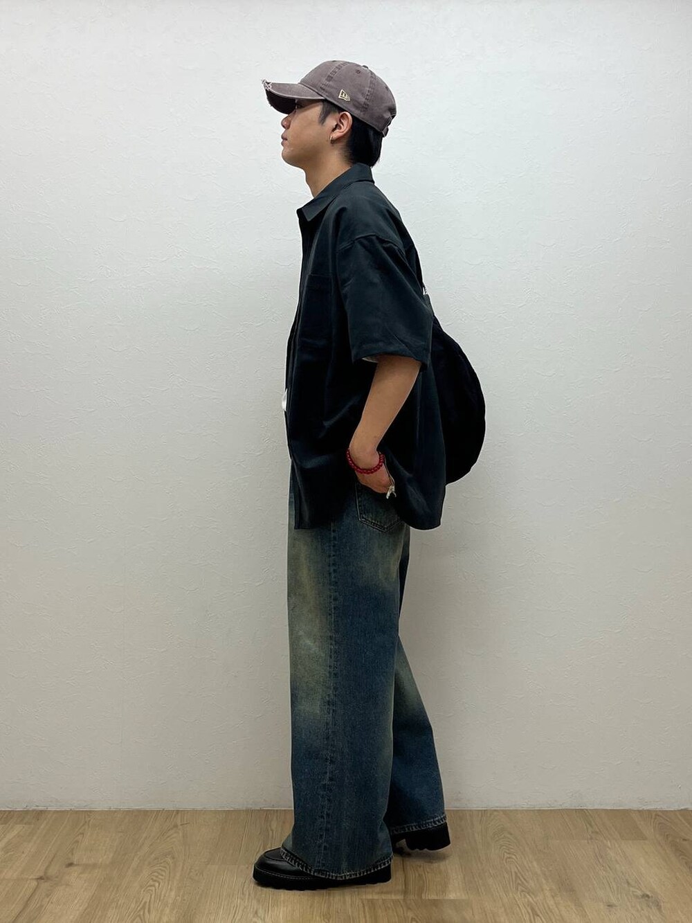 ブルー系のデニムパンツ、ブラック系のドレスシューズ、ホワイト系のTシャツ/カットソーを着用したメンズの夏コーディネートの2枚目の写真