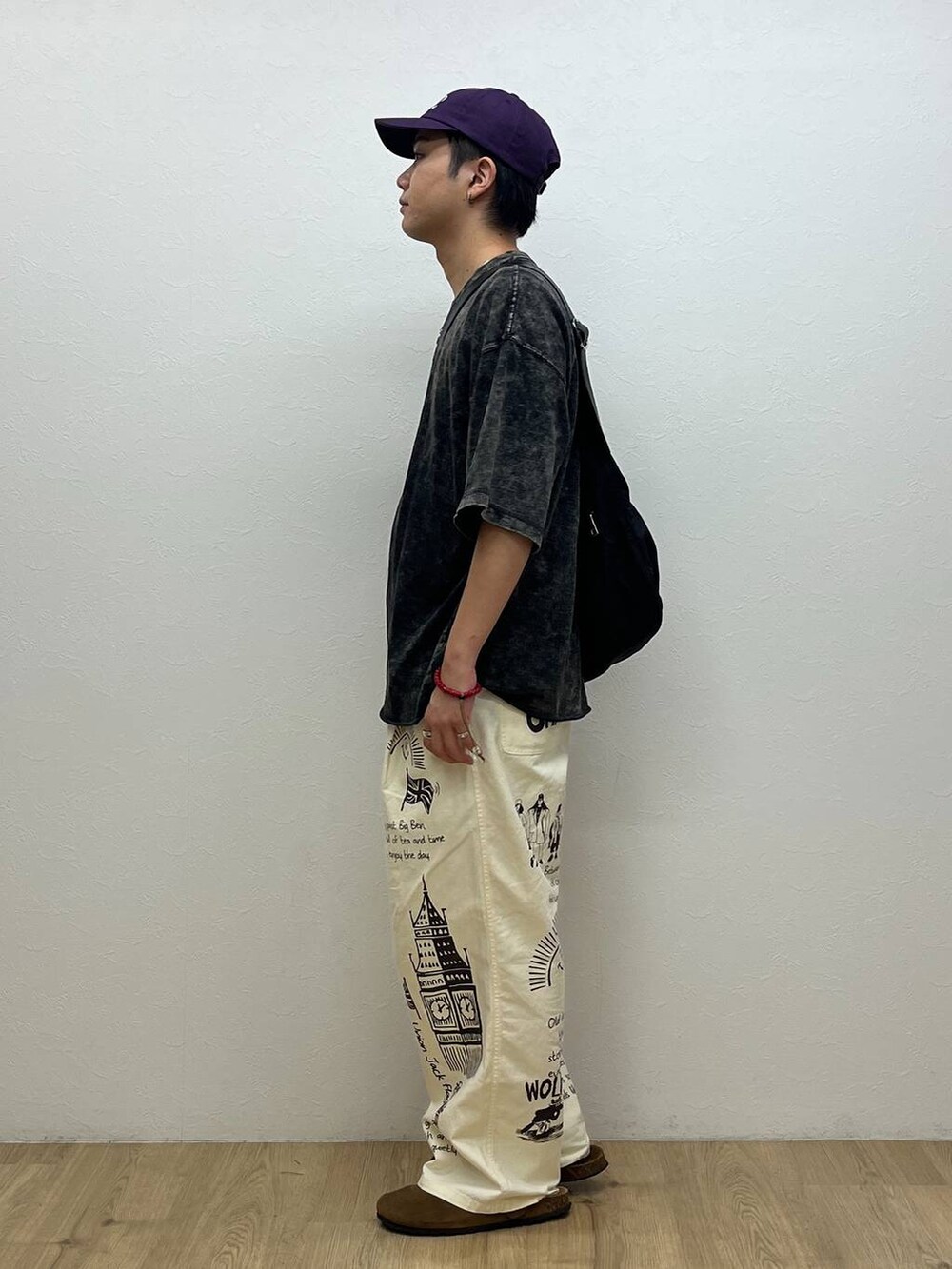 グレー系のTシャツ/カットソー、ブラック系のショルダーバッグ、ホワイト系のチノパンツを着用したメンズの夏コーディネートの2枚目の写真