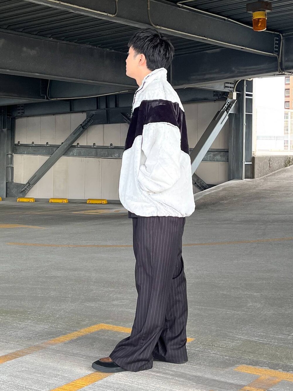 ブラック系のスラックス、グレー系のブルゾン、ブラック系のスウェットを着用したメンズの冬コーディネートの2枚目の写真