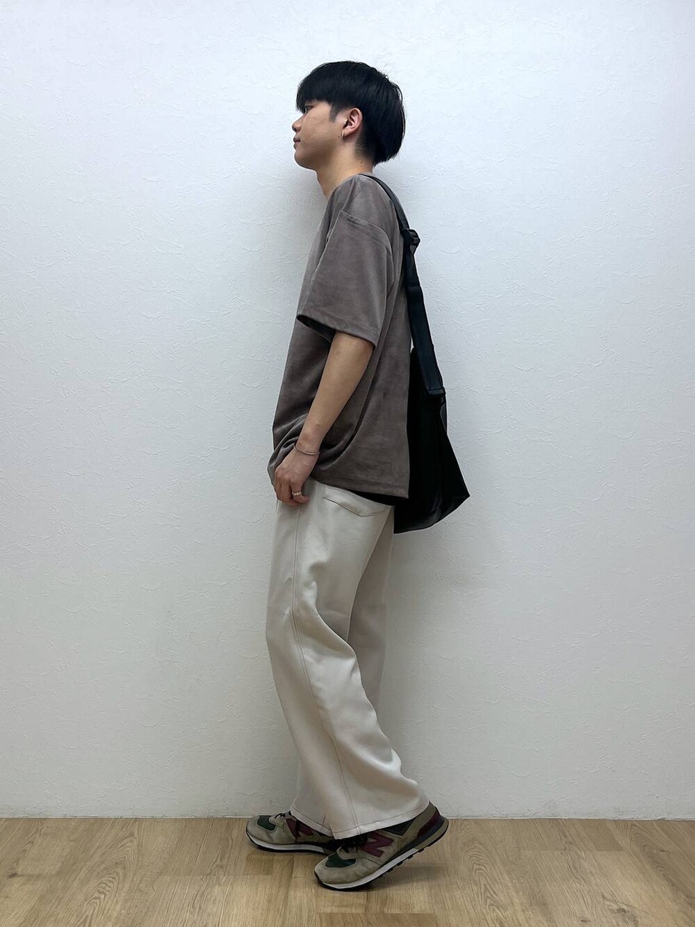 ブラック系のショルダーバッグ、ホワイト系のスラックス、ベージュ系のTシャツ/カットソーを着用したメンズの夏コーディネートの2枚目の写真