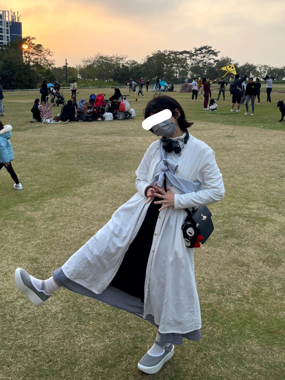 グレー系のシューズ、ブラック系のバッグ、ホワイト系のワンピース/ドレスを着用したレディースの冬コーディネートの2枚目の写真