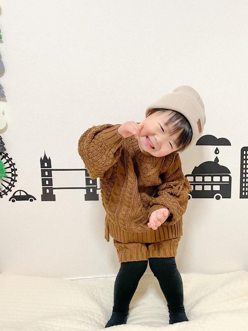 ブラウン系のニット/セーター、ブラウン系のその他パンツ、ベージュ系のニットキャップ/ビーニーを着用したキッズの冬コーディネートの3枚目の写真