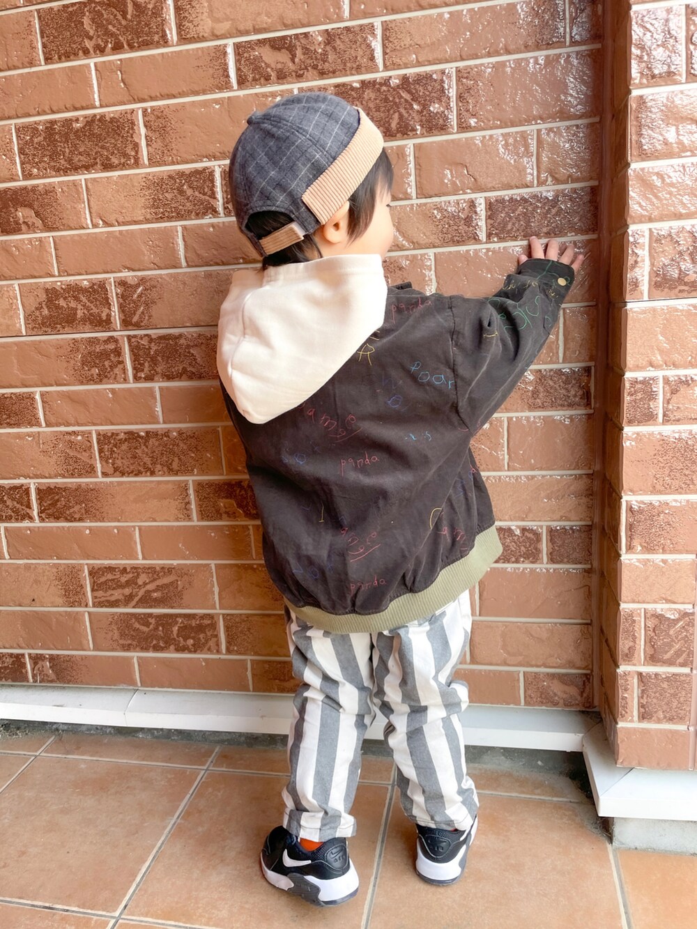 ホワイト系のパーカー、グレー系のその他パンツ、ブラック系のスニーカーを着用したキッズの春コーディネートの2枚目の写真