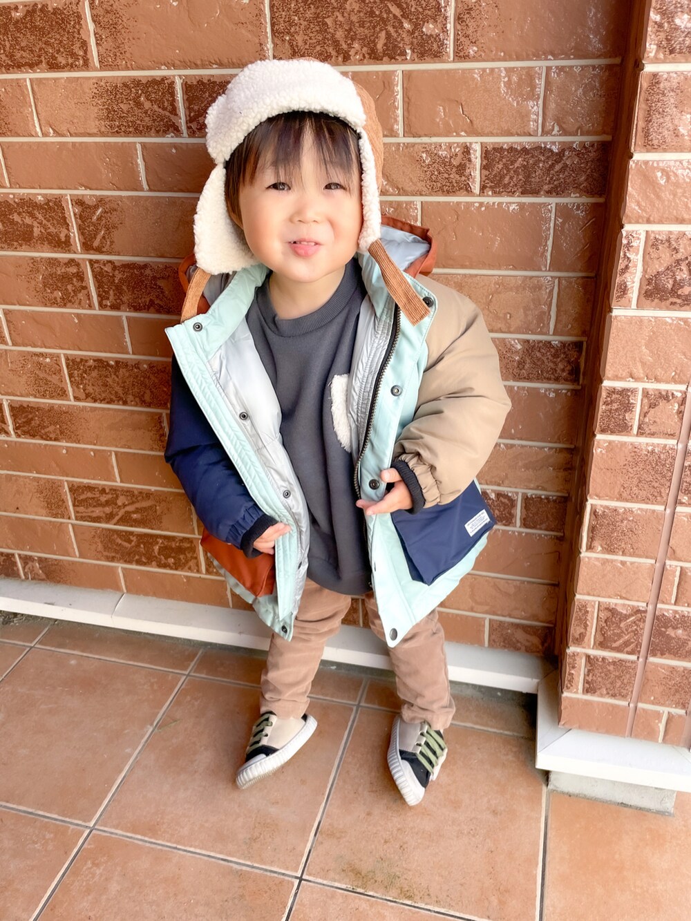 グレー系のスウェット、ブラウン系のパンツ、その他のスニーカーを着用したキッズの冬コーディネートの2枚目の写真