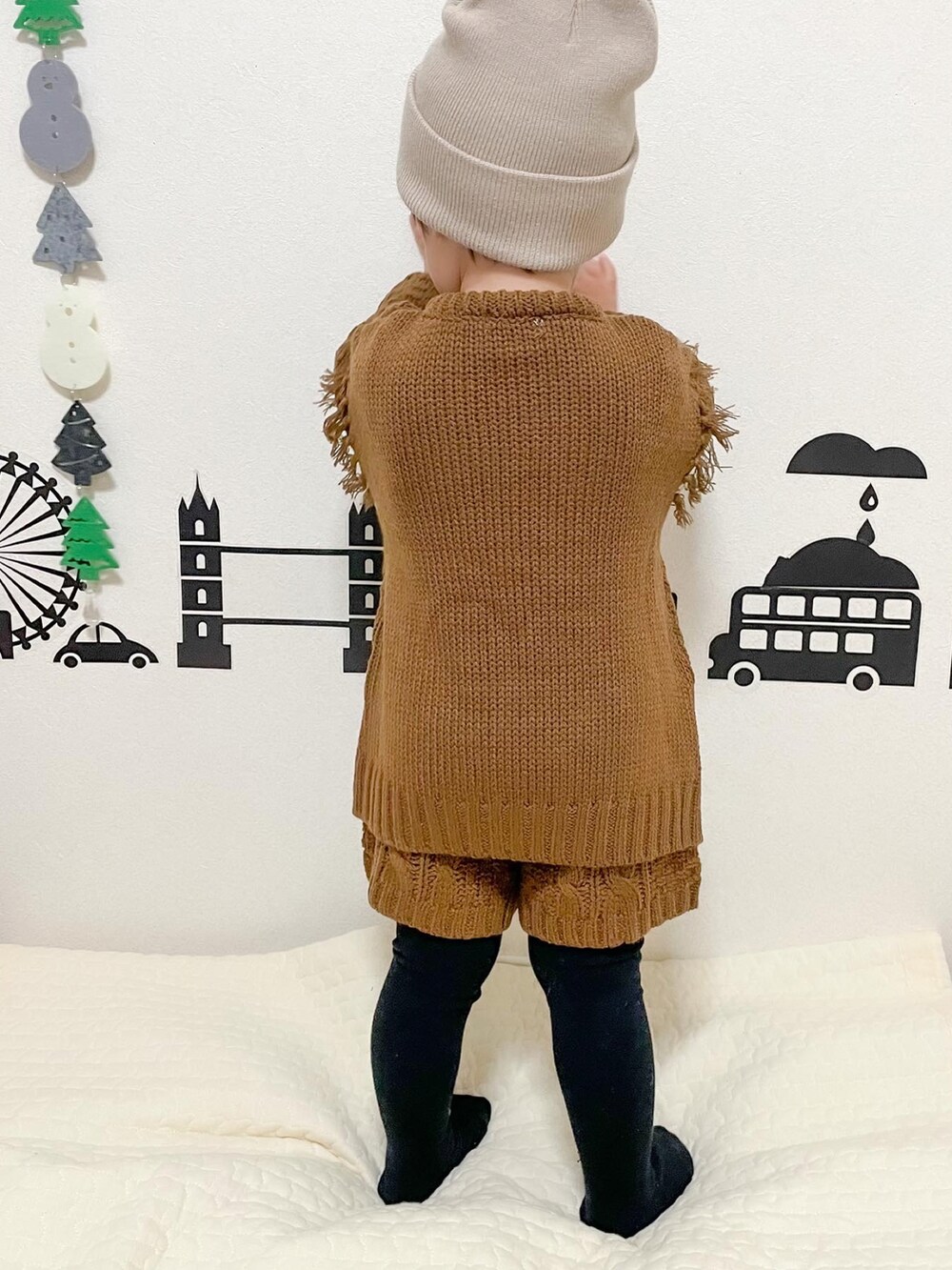 ブラウン系のニット/セーター、ブラウン系のその他パンツ、ベージュ系のニットキャップ/ビーニーを着用したキッズの冬コーディネートの4枚目の写真