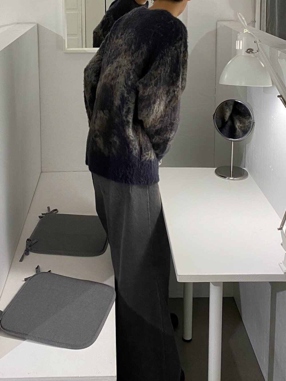 ブラウン系のニット/セーター、グレー系のスラックス、ブラック系のブーツを着用したメンズの秋コーディネートの3枚目の写真