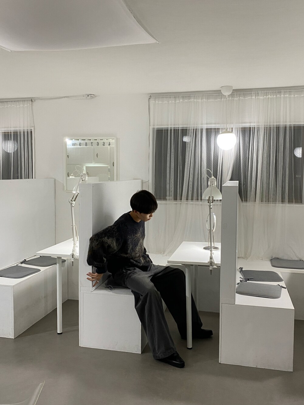 ブラウン系のニット/セーター、グレー系のスラックス、ブラック系のブーツを着用したメンズの秋コーディネートの5枚目の写真