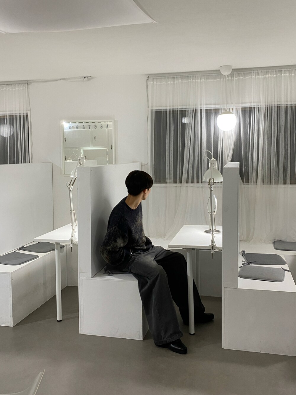 ブラウン系のニット/セーター、グレー系のスラックス、ブラック系のブーツを着用したメンズの秋コーディネートの4枚目の写真