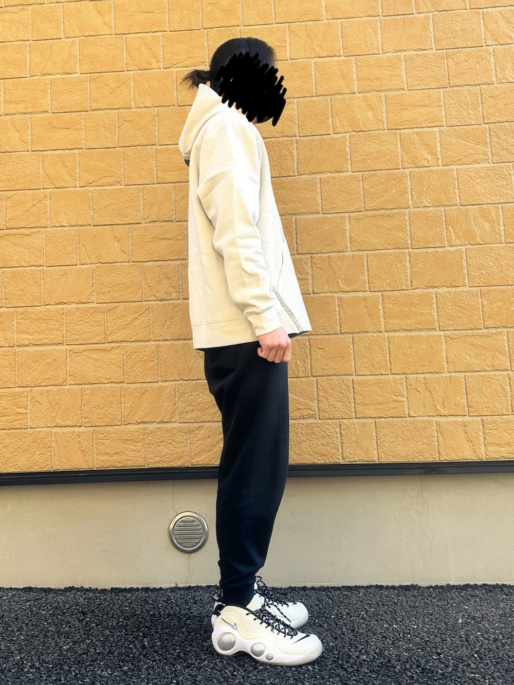 ブラック系のスウェットパンツ、ホワイト系のスニーカー、ホワイト系のパーカーを着用したメンズの冬コーディネートの2枚目の写真