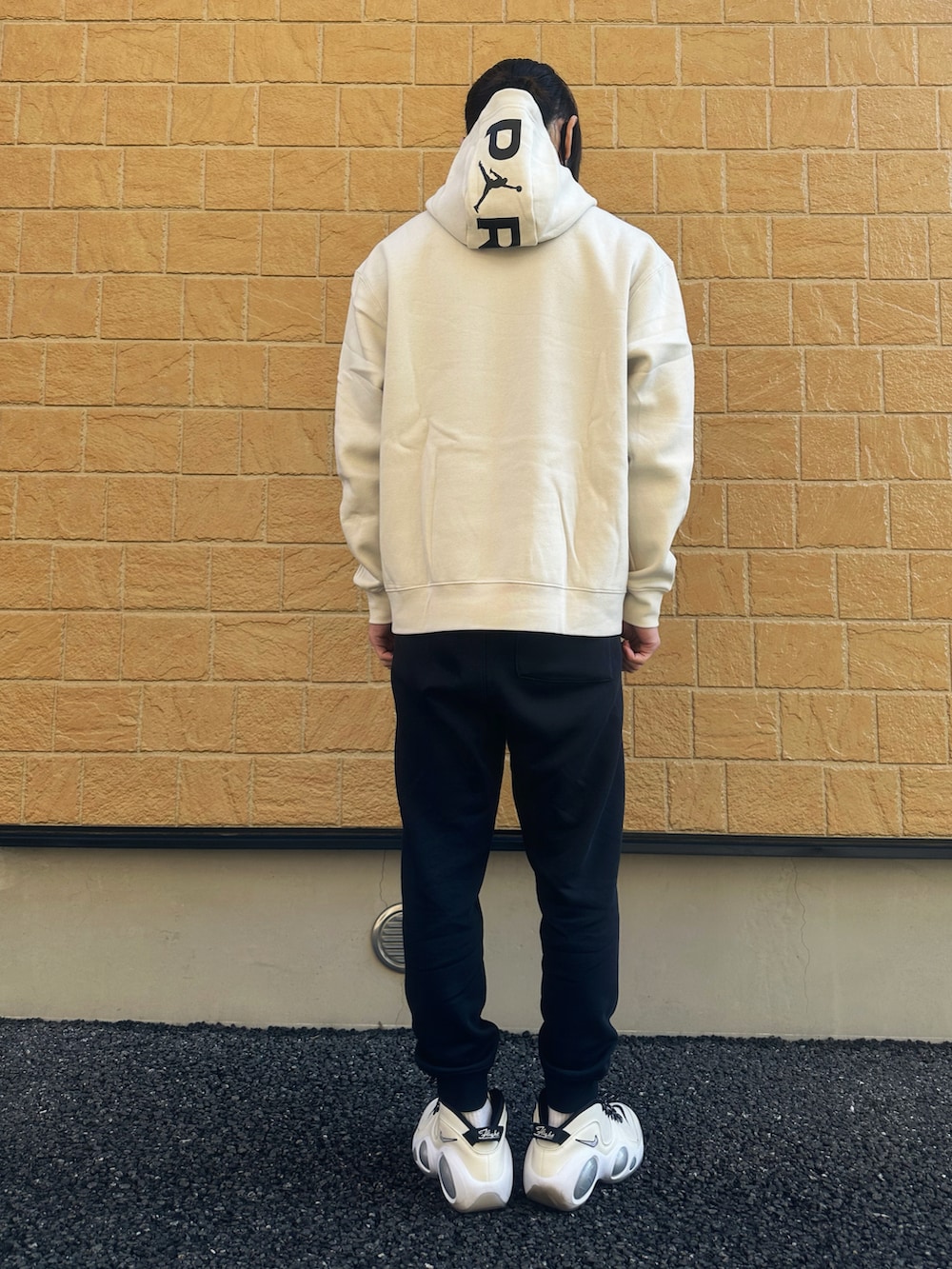 ブラック系のスウェットパンツ、ホワイト系のスニーカー、ホワイト系のパーカーを着用したメンズの冬コーディネートの3枚目の写真