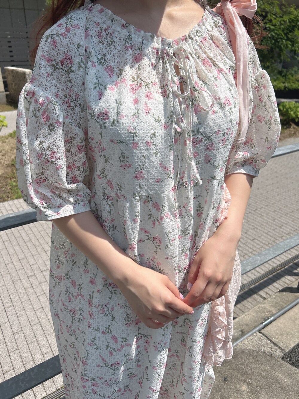 ピンク系のワンピース、ピンク系のトートバッグ、ホワイト系のスニーカーを着用したレディースの夏コーディネートの8枚目の写真