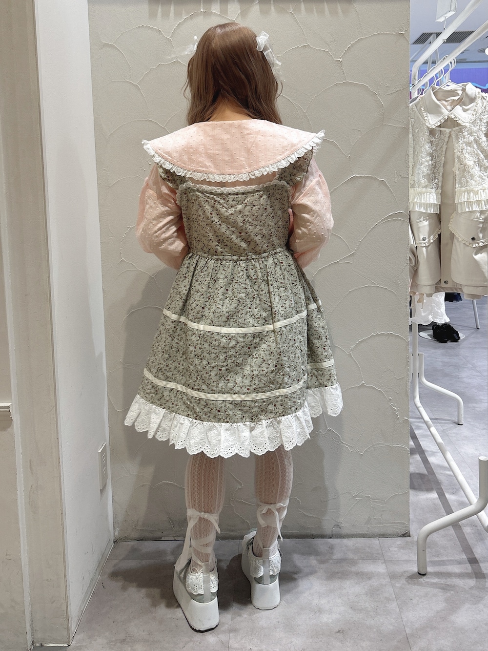 グリーン系のワンピース、ピンク系のシャツ/ブラウス、グリーン系のスニーカーを着用したレディースの冬コーディネートの4枚目の写真