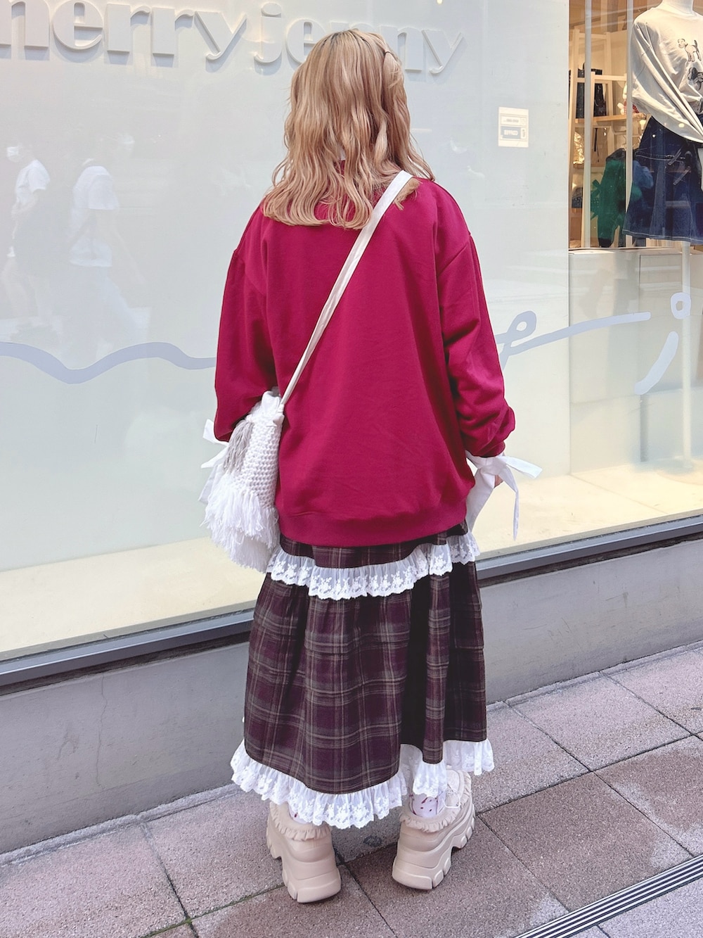 レッド系のスウェット、ホワイト系のシャツ/ブラウス、ブラウン系のスカートを着用したレディースの秋コーディネートの4枚目の写真