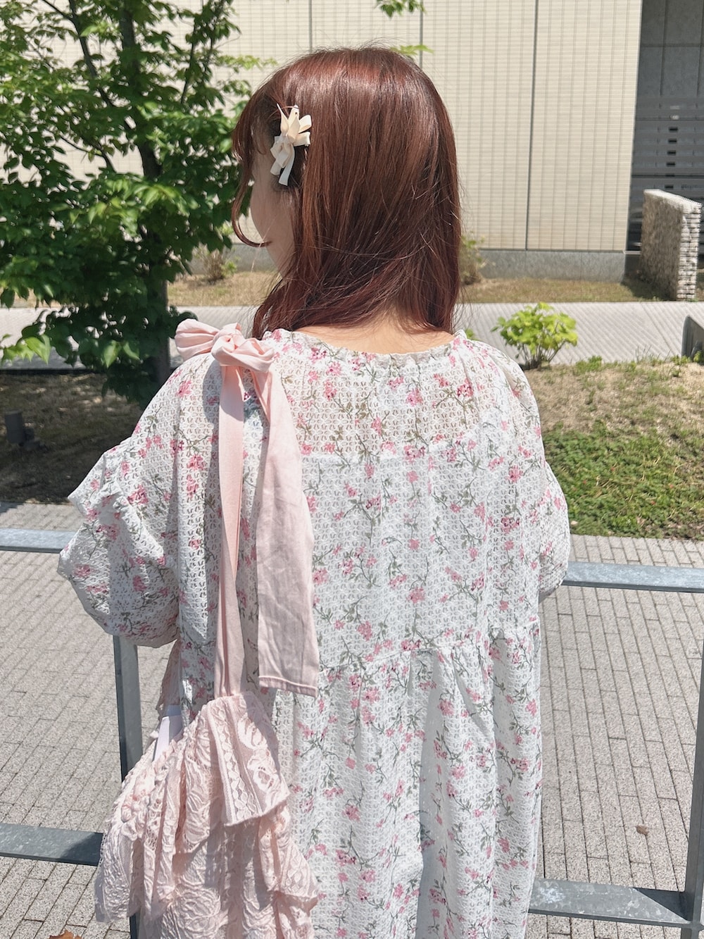 ピンク系のワンピース、ピンク系のトートバッグ、ホワイト系のスニーカーを着用したレディースの夏コーディネートの5枚目の写真