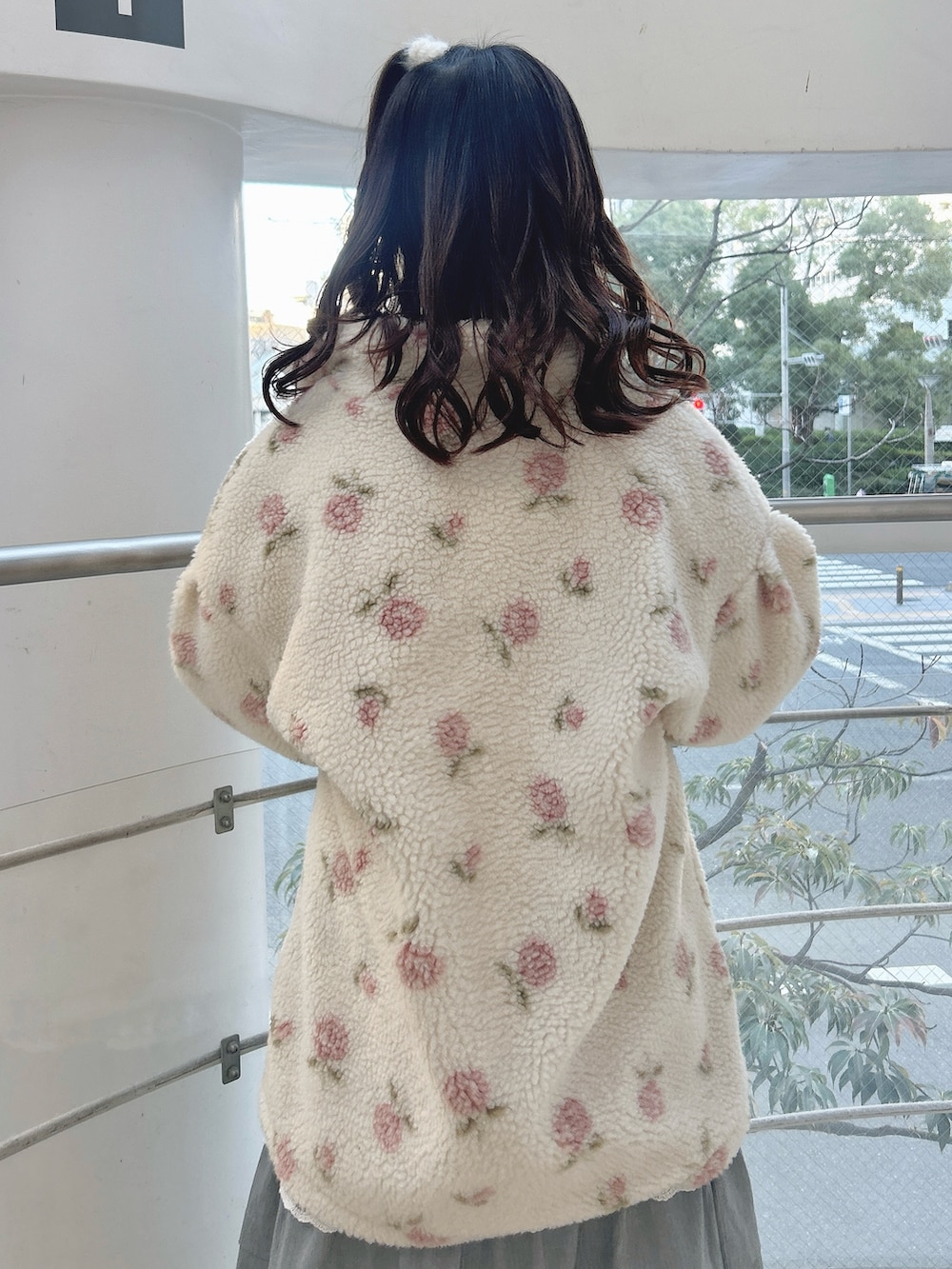 ピンク系のブルゾン、ピンク系のニット/セーター、グレー系のスカートを着用したレディースの冬コーディネートの5枚目の写真