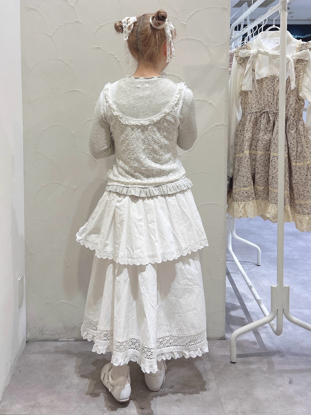 グレー系のTシャツ/カットソー、ホワイト系のスカート、ホワイト系のスニーカーを着用したレディースの冬コーディネートの3枚目の写真