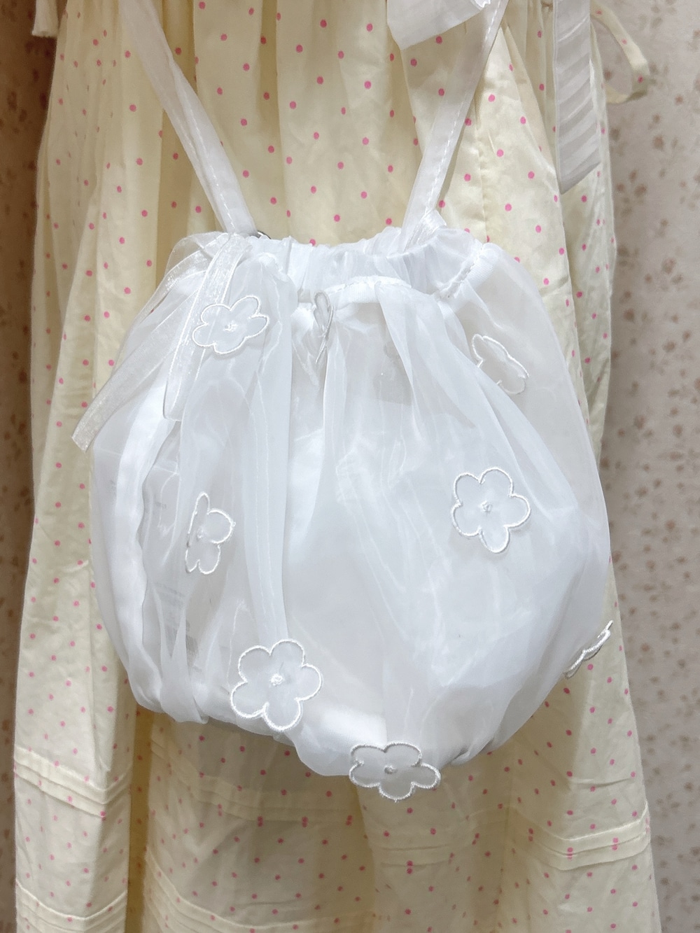 ベージュ系のワンピース、ホワイト系のハンドバッグ、ホワイト系のスニーカーを着用したレディースの冬コーディネートの8枚目の写真