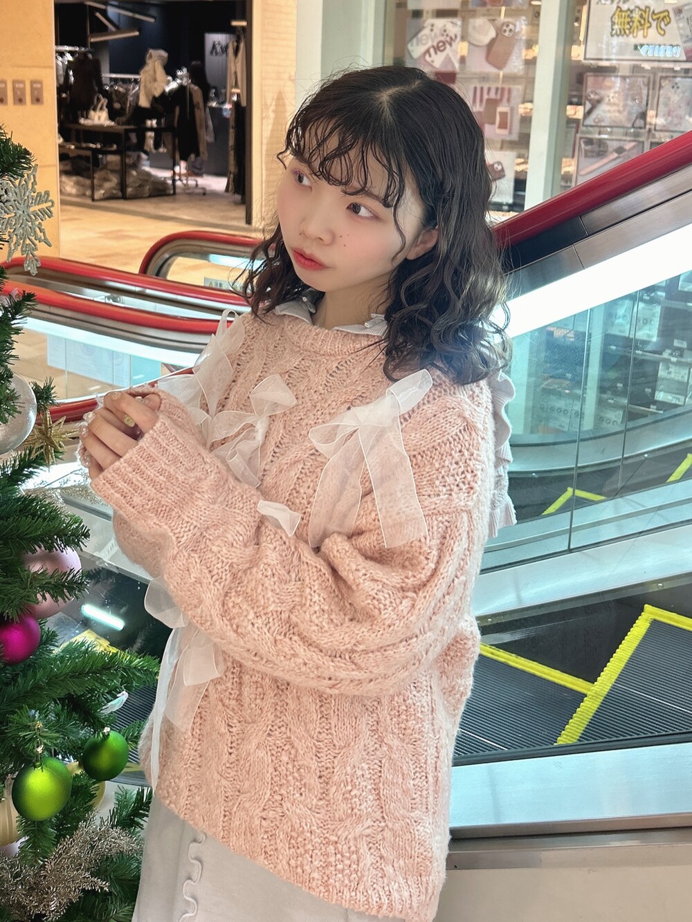 ピンク系のニット/セーター、ブルー系のワンピース、ブルー系のデニムパンツを着用したレディースの冬コーディネートの5枚目の写真