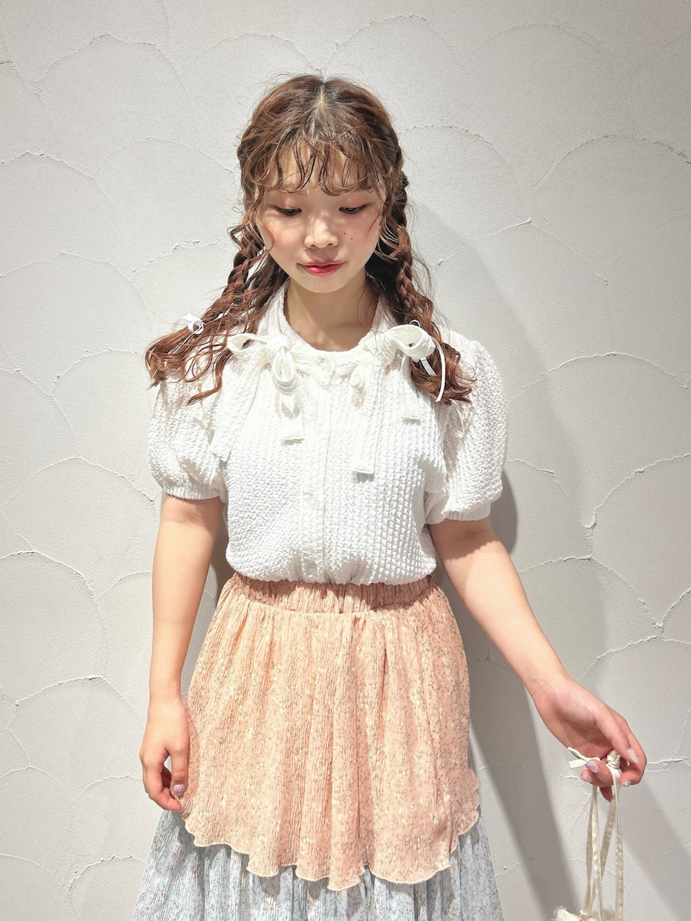 ピンク系のスカート、ホワイト系のシャツ/ブラウス、ホワイト系のショルダーバッグを着用したレディースの夏コーディネートの4枚目の写真