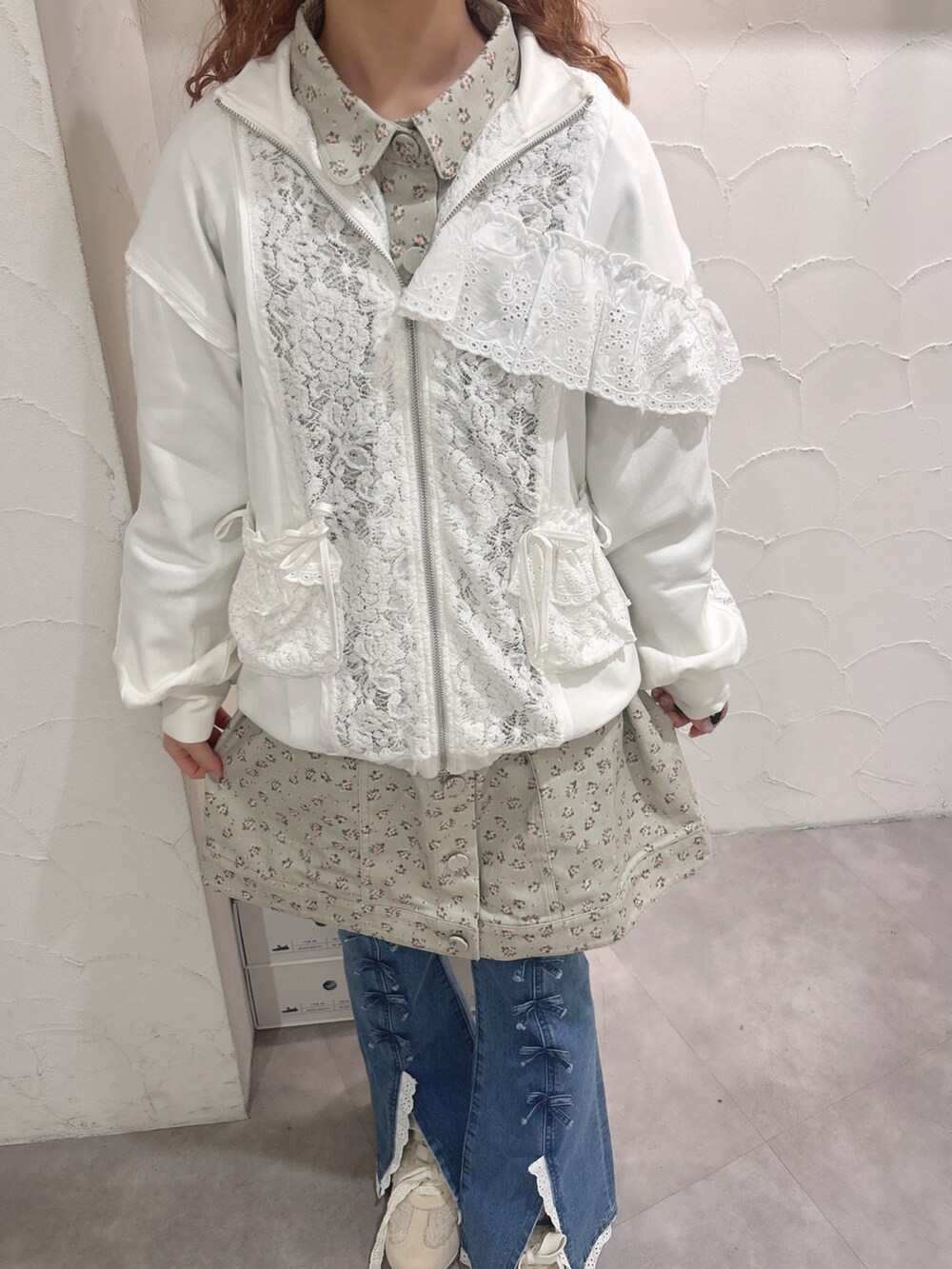 グリーン系のワンピース、ホワイト系のジャージ、ブルー系のデニムパンツを着用したレディースの秋コーディネートの9枚目の写真