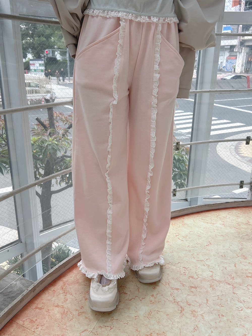 ホワイト系のブルゾン、グリーン系のTシャツ/カットソー、ピンク系のスウェットパンツを着用したレディースの冬コーディネートの9枚目の写真